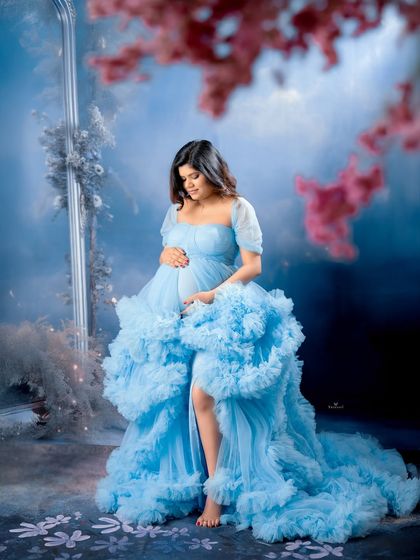 A dreamy and contemplative portrait. The mom-to-be is surrounded by a soft, misty blue atmosphere, creating a peaceful and magical scene.