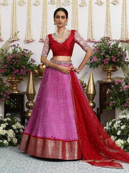 The rich red dupatta adds a touch of bridal grandeur to the playful pink lehenga.
