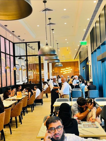 The lively interior of the PAUL cafe, with families and friends enjoying their meals. These are the moments that bring a place to life.