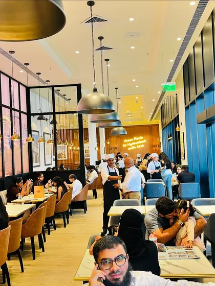 The lively interior of the PAUL cafe, with families and friends enjoying their meals. These are the moments that bring a place to life.