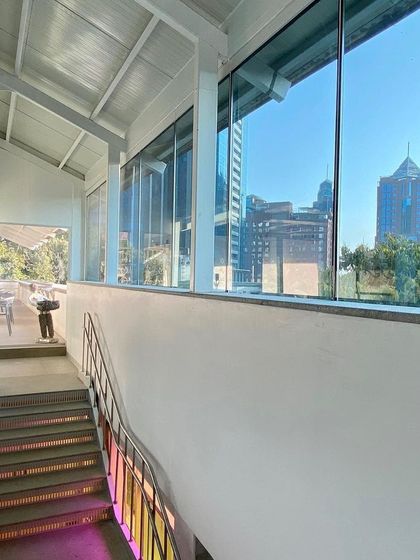 A view from the upper levels of the MAP museum, looking out towards the Bangalore skyline. The building's design frames views of the city, constantly connecting the art within to the context of the world outside.