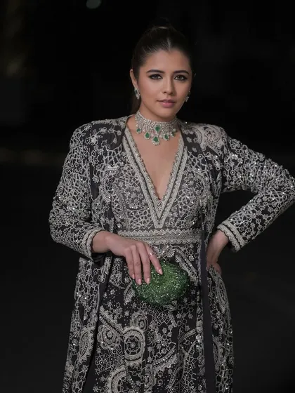 This look is major sangeet inspiration. The luminous, striking glam with defined eyes is perfect for a festive evening. The makeup is designed to complement the intricate black and silver outfit, creating a cohesive and memorable look.