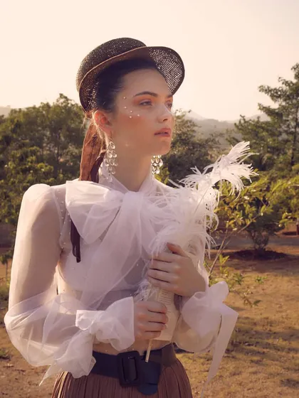 For Starchthelabel's 'White Rose' collection, I developed a romantic, vintage-inspired creative concept. This portrait captures the poetic and dreamy mood, with delicate styling details like the sheer bow blouse, feathered accessory, and soft lighting to tell a story of timeless elegance.