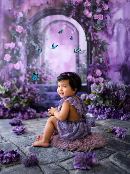 A lovely portrait of this baby girl looking back with a sweet smile in her purple wonderland.