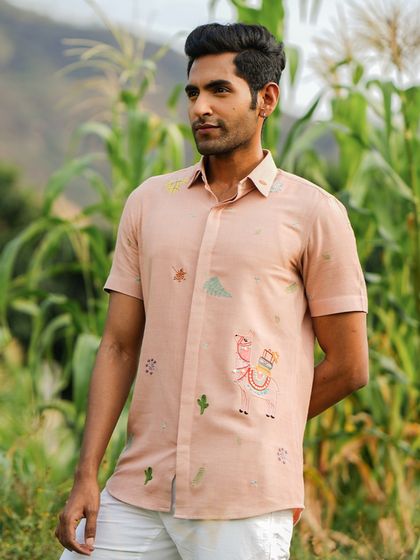 The 'Peachy Llama' shirt, featuring whimsical hand-embroidered llamas. This holiday shirt is perfect for someone who embodies intelligence, gentleness, and calmness.