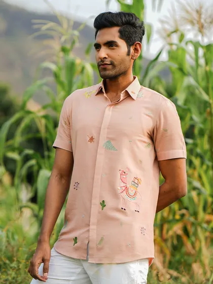 The 'Peachy Llama' shirt, featuring whimsical hand-embroidered llamas. This holiday shirt is perfect for someone who embodies intelligence, gentleness, and calmness.