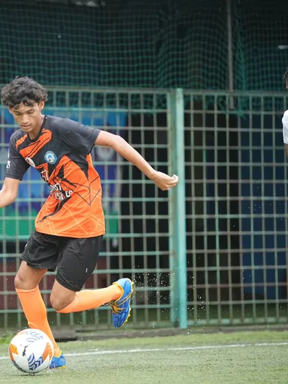 A player maintains close control of the ball while driving forward against the Worli Warriors defense.
