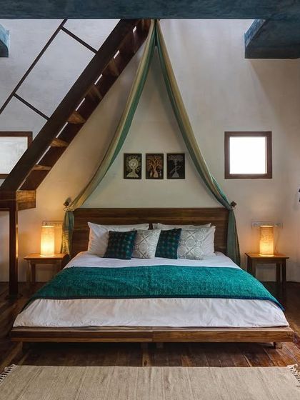 The Tower Room is the highest point of the villa, offering a unique double-height space with a staircase leading to a private terrace. The design combines traditional elements like a canopy bed with modern comforts.