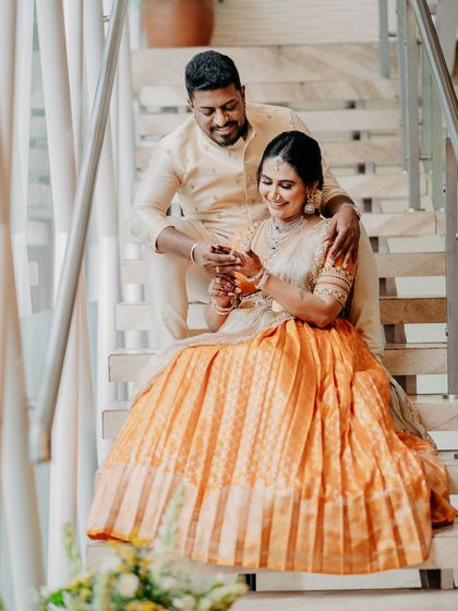 Another intimate moment between the couple on the stairs. The soft lighting highlights the rich texture of their silk outfits.