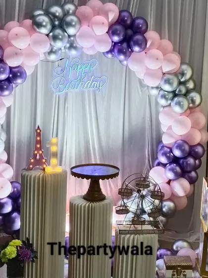 A simple and elegant ring decoration with pink, purple, and silver balloons against a white curtain. The "BABY" blocks add a sweet touch.
