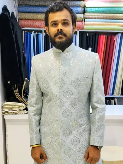 A client looking sharp in a custom-made, light-colored sherwani. This piece showcases my commitment to creating ethnic wear that fits perfectly and reflects your personal style.