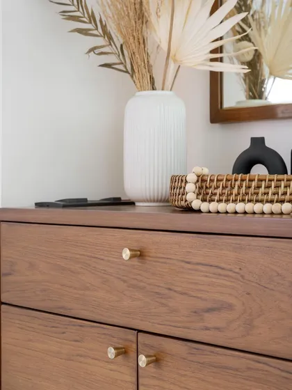 A close-up of the top of the 'Marshall' shoe cabinet, highlighting the simple, elegant brass knobs and the seamless finish.