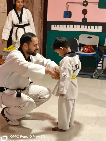 A young boy receives his first colored belt. This is the beginning of an exciting journey up the Taekwondo ladder.