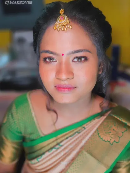 A close-up of this bride's engagement look, featuring a simple green and cream saree. The makeup is minimal and fresh, with a pop of pink on the lips.