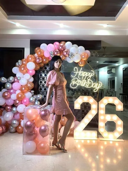 This pose shows off the clear pedestal filled with balloons, a modern touch that adds another layer of detail to the overall decoration.