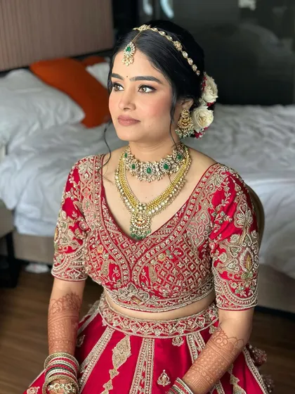This bride is poetry in red. The makeup is soft and flawless, blending tradition with freshness. Her skin is luminous, and her eyes are subtly defined to create a hint of bridal boldness.