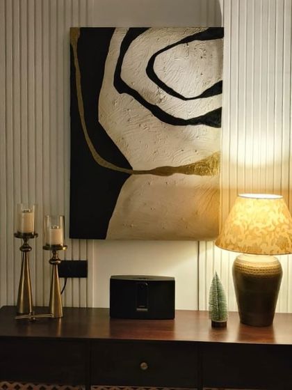 A black, white, and gold abstract piece installed above a console table in a Delhi residence. The metallic gold lines add a touch of warmth and luxury to the monochromatic design.