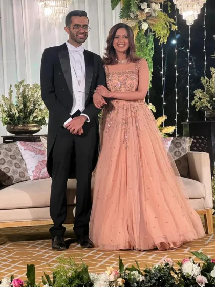 A picture of pure elegance. This groom is dressed in a traditional black tailcoat tuxedo with a white waistcoat, a classic and distinguished choice for a formal wedding reception or white-tie event.