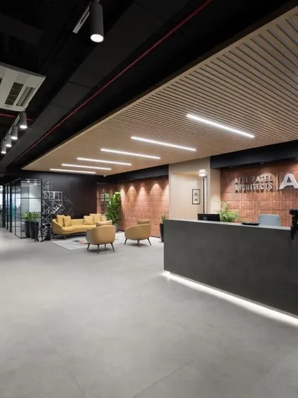 A full view of the reception and entrance, showcasing the clean lines, integrated lighting, and a material palette that reflects a modern, design-forward company.