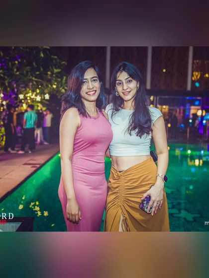 Guests posing by the beautifully lit pool at Taj MG Road. The venue's ambiance perfectly complements the music for a classy evening.