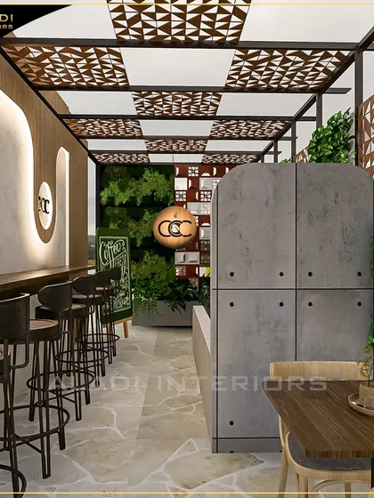 This view highlights the bar and solo seating area of a cafe project. The design features a geometric patterned ceiling, a vertical garden for a touch of nature, and industrial-style bar stools, creating a distinct zone with a modern, urban feel.