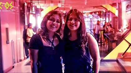 Two friends posing for a photo, capturing the excitement and glamour of our New Year's party.