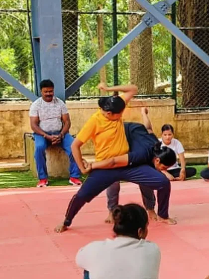 We teach practical takedown maneuvers that are effective regardless of size or strength. This image captures a demonstration of a leverage-based technique, a critical skill taught in our advanced self-defense workshops for women.