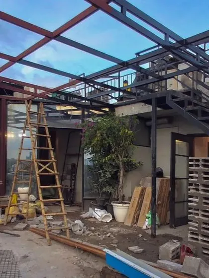 Keep it raw. A look at the structural work for an outdoor cafe space. The steel framework for the roof and the stacked concrete blocks for the walls are the bones of this industrial-themed design.