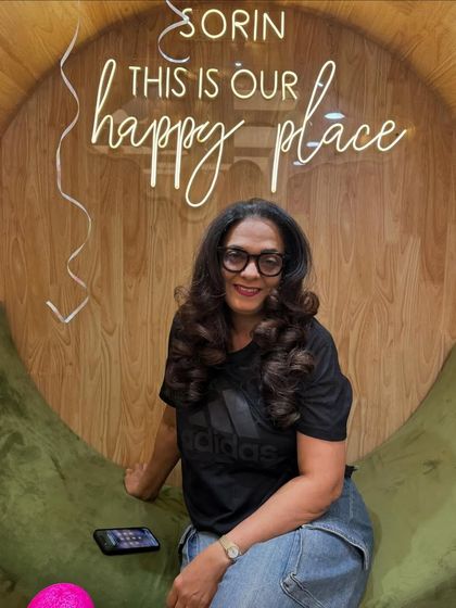 A happy client relaxing in our signature chair. The "happy place" sign says it all.