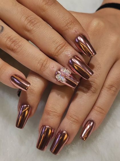 For a high-impact, futuristic look, I used a rose gold chrome powder on these long, square-shaped extensions. The 3D crystal bow on the accent nail adds a touch of feminine glam.