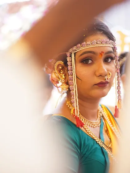 Another artistic shot of the bride, peeking through the antarpat. The focus is on her expressive eyes, enhanced with subtle eyeshadow and liner.