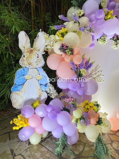 A close-up of the Peter Rabbit cutout and the beautiful pastel balloon garland with fresh flower accents.