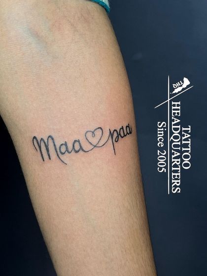 A simple yet heartfelt "Maa paa" tattoo with an ambigram-style heart connecting the two words, symbolizing parental love.