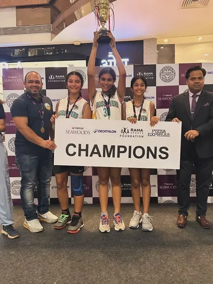Another angle of our U-14 girls' team celebrating their championship at the Seawoods mall event, holding their trophy high.