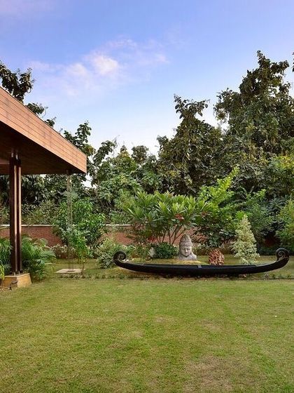 The K Pavilion was designed to bind an existing home with its garden, creating a seamless whole. This view shows the pavilion's connection to the lush lawn, with a traditional boat repurposed as a water feature and planter.