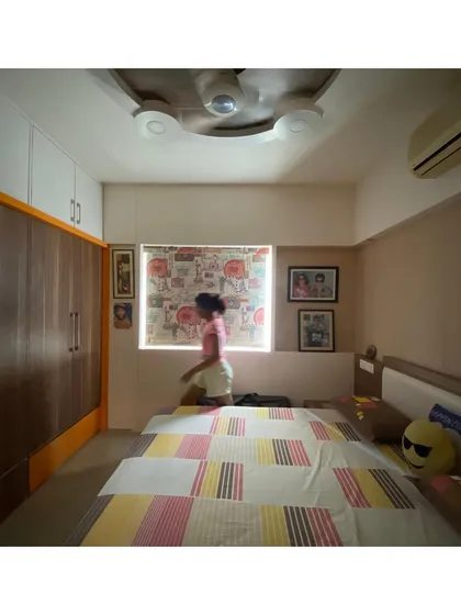 This image captures a moment of daily life, showing how the room's design provides a comfortable and functional backdrop for a child's activities.