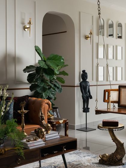 In my 'Kaalam' project, every corner tells a story of culture and craft. Here, a traditional bronze statue and a wooden swing with cane details are set against a backdrop of clean, modern wall molding. It’s a space that celebrates heritage with a contemporary spirit.