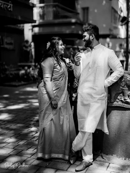 A relaxed, candid moment captured in black and white, showing the easy chemistry between Nidhi and Aditya.