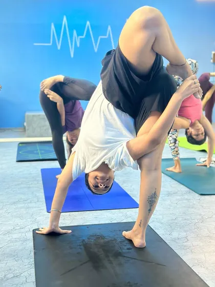 A student exploring a standing split variation in our Malad class. We encourage students to find their own expression of each pose.