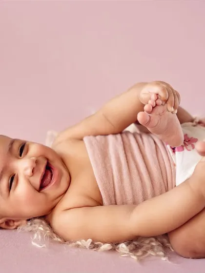 The pure joy of a 4-month-old who has discovered her feet! These milestone sessions are filled with laughter and adorable moments.