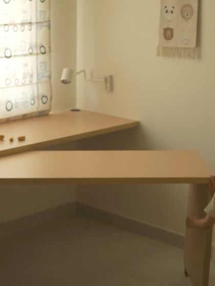 A child interacts with the custom-designed openable study desk, showing how it can be easily transformed from a compact unit to a spacious L-shaped table.