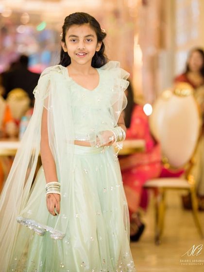 A sweet young girl dressed in a light mint green lehenga with a ruffled dupatta. This outfit is perfect for a Mehendi function or a summer wedding.