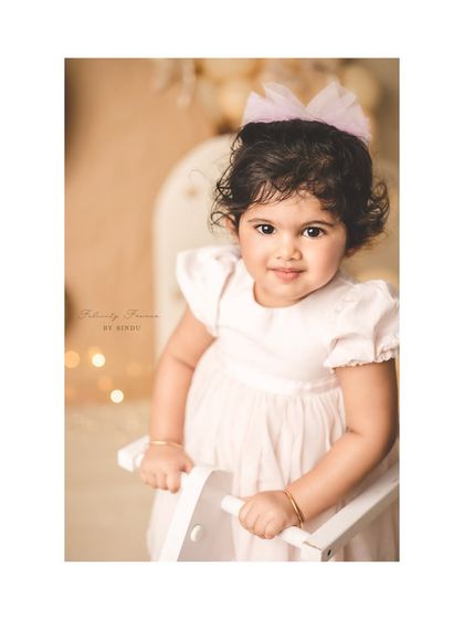 A close-up portrait of a sweet two-year-old girl. The soft lighting and neutral tones create a beautiful, timeless look.