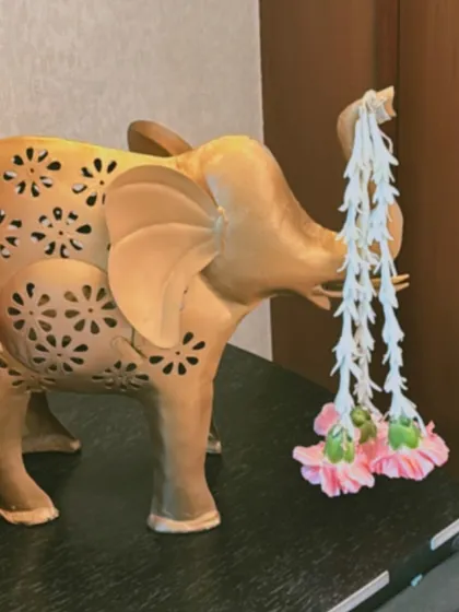 Small, thoughtful details can make a big impact. Here, a decorative elephant statue is adorned with a delicate garland of fresh flowers, adding a touch of traditional charm to the decor.