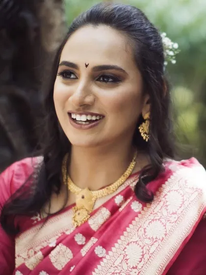 A candid shot of the smiling bride. Her natural, glowing makeup and soft hairstyle look just as stunning in natural light as they do indoors.