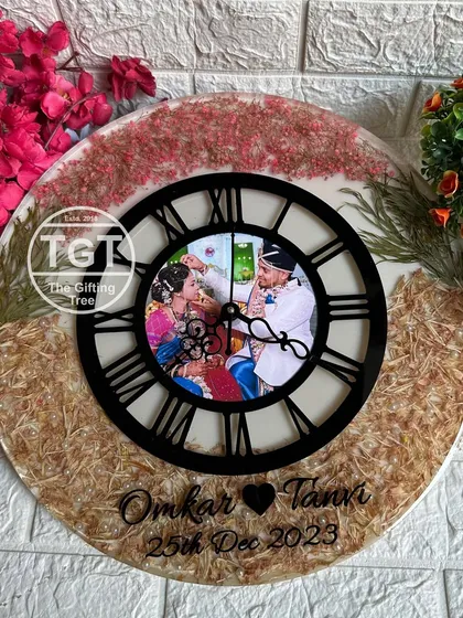 This full view of the large resin clock shows the balance between the two types of preserved flowers and the bold central dial.