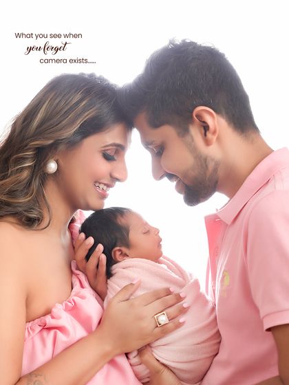 A candid moment where the family forgets the camera exists. The parents are lost in the moment, admiring their new baby, creating an authentic and emotional portrait.