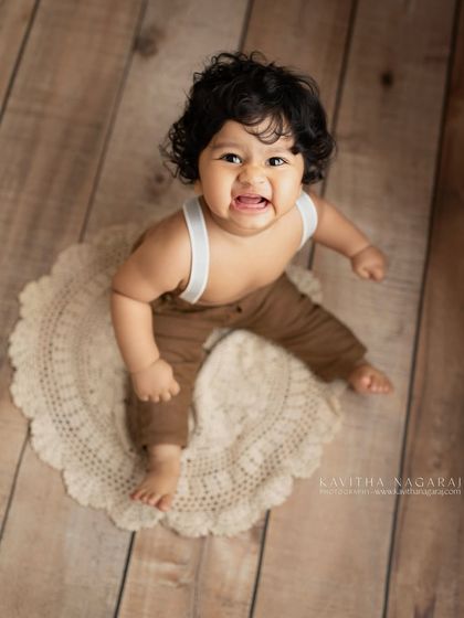 A nine-month-old with curious eyes and a big, bright smile. The sitter stage is full of these expressive moments that you'll want to remember forever.