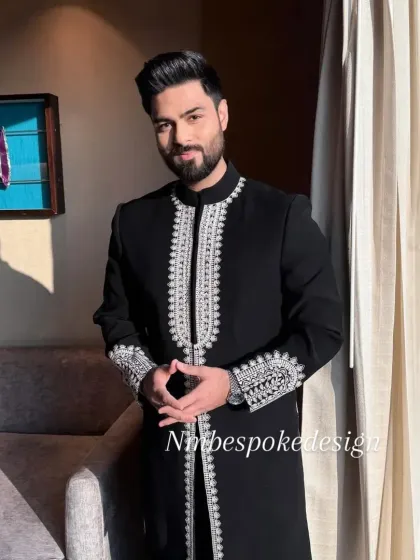 A smiling client wearing the black and silver embroidered indowestern jacket.