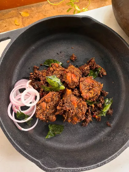 This is our Kovalam Smoky Roasted Chicken. The chicken is marinated in traditional stone-ground spices and smoke-cooked, Chuttathu style. Each piece is packed with robust, spicy flavours, making this dish absolutely drool-worthy.